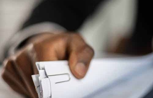 Person reviewing resource consent application documents and site plans at a desk