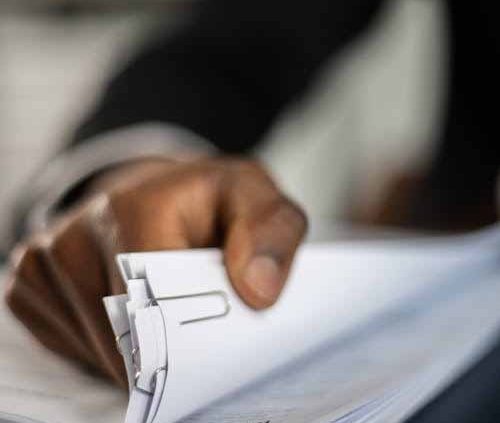 Person reviewing resource consent application documents and site plans at a desk