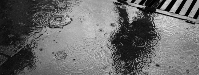 Rainwater pooling around a stormwater drain during heavy rainfall on an Auckland development site