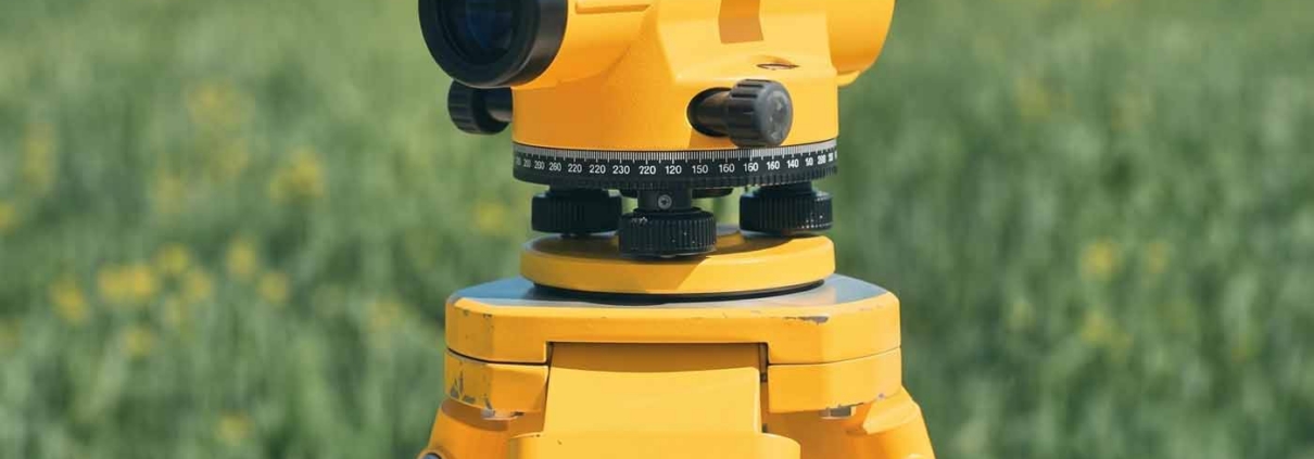 Survey level on a tripod in an open field ready for a site survey