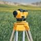 Survey level on a tripod in an open field ready for a site survey